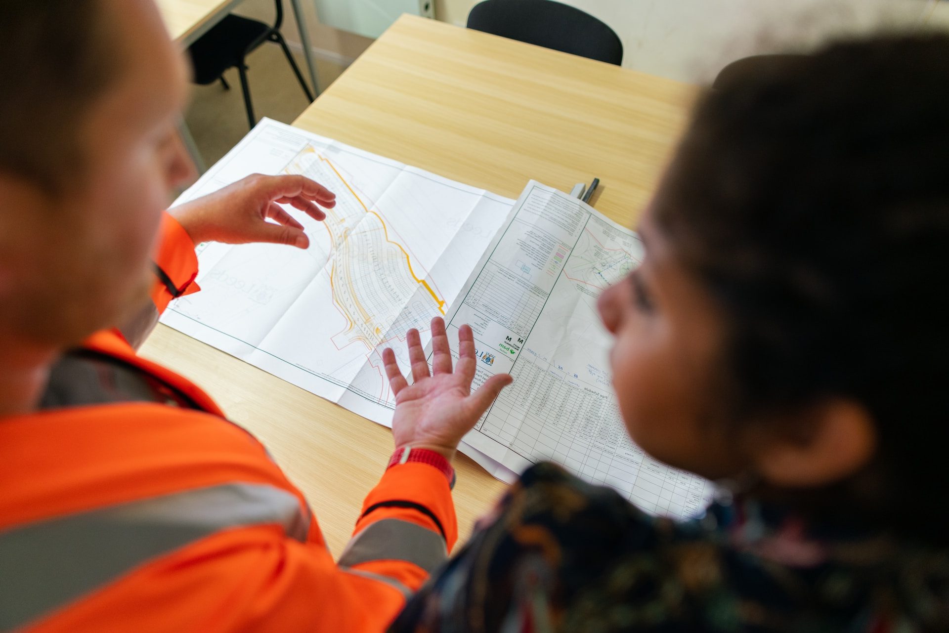 boy in orange long sleeve shirt writing on white paper